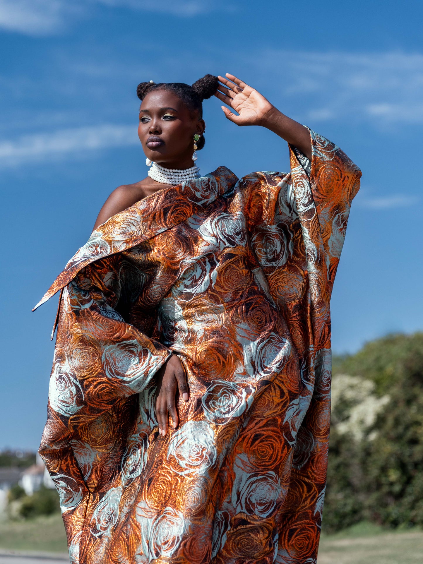 Model wearing the Malika Bubu Dress in metallic copper and soft aqua floral organza brocade.
